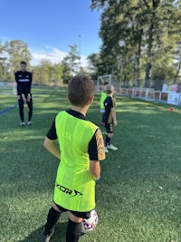 a young boy is standing on a soccer field